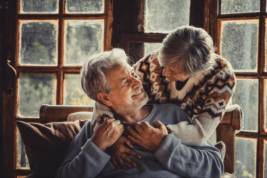 An elderly couple embracing in a cozy home to represent guide to living with CKD